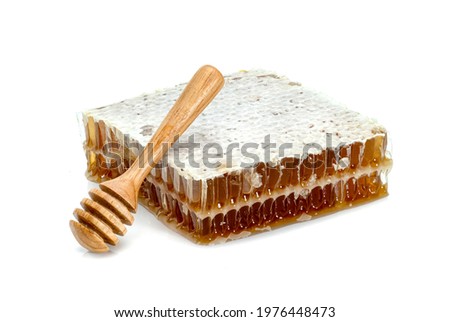 Fresh Honeycomb slice and wooden honey dipper isolated on white background 