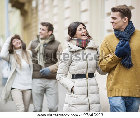 Happy couples in warm clothing enjoying vacation