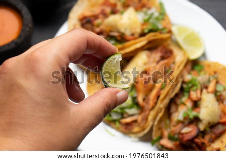 Pork tacos called al pastor with pineapple on dark background. Traditional mexican tacos