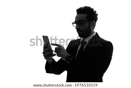 Silhouette of arabian businessman using a smart phone.