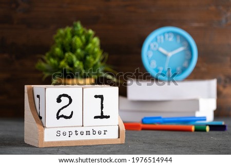 September 21st. September 21 wooden cube calendar with blur objects on background.