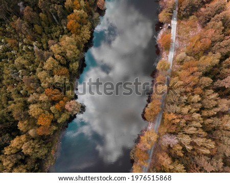View of the river in the autumn forest from above. Beautiful panoramic view of the wildlife. Shooting from a drone. Wallpaper, screen saver, cover.