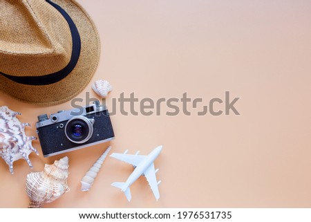 Summer background, model airplane, camera, sun hat, seashells. Vacation and travel concept.