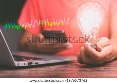 hand of a man with a light bulb And there is a gear icon planning and strategy, Stock market, Business growth, progress or success concept.