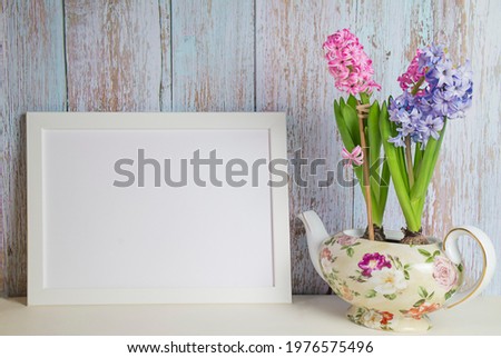 Blooming hyacinths and picture frame with copy space for mockup. High quality photo
