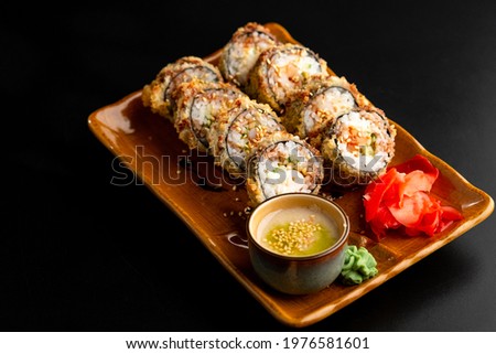 Sushi and rolls, Japanese sea cuisine. Served plates for the restaurant menu on a black background. Close-up.