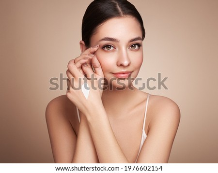 Beauty woman applying cream on her hands. Young woman with clean fresh skin Royalty-Free Stock Photo #1976602154