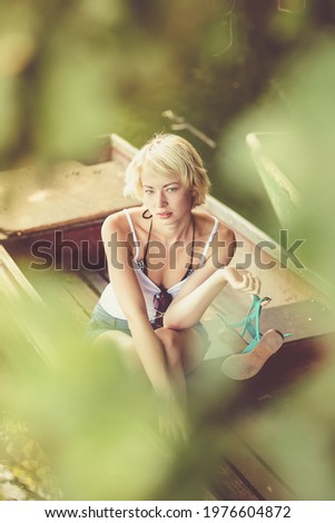 Woman relaxing on the vintage wooden boat.