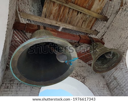 Large church bells hang under the arch of the bell tower