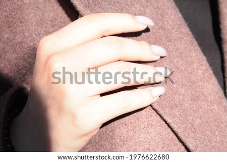 female hand on purple background with gray manicure