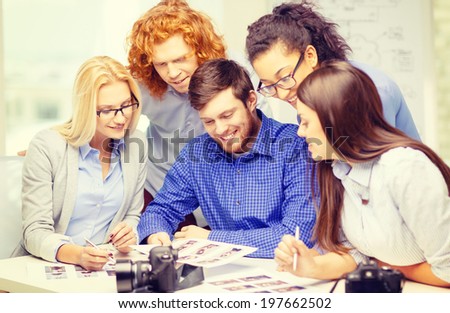 business, office and startup concept - smiling creative team with photocameras and images working in office