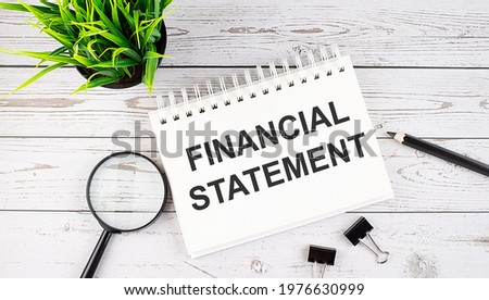 FINANCIAL STATEMENT text concept write on notebook with office tools on wooden background