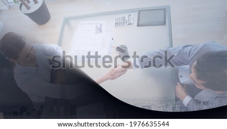 Composition of businessman and businesswoman shaking hands in office with dark shadow. business, finance and success concept digitally generated image.
