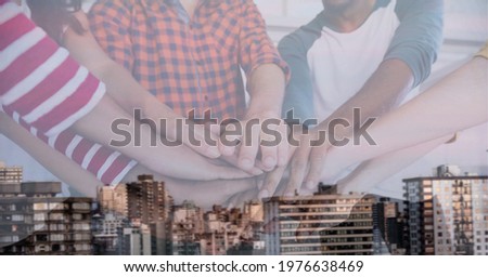 Composition of midsection of office colleagues hand stacking over cityscape. teamwork, success, business and finance concept digitally generated image.