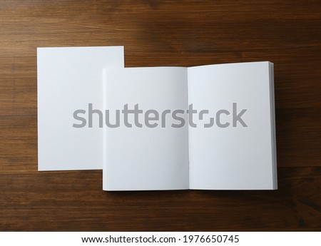 Sheet of paper and blank brochure on wooden table, flat lay. Mockup for design
