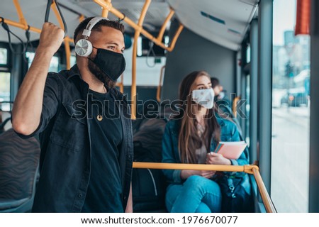 Passengers wearing protective mask while riding a bus and keeping the distance due to a corona virus pandemic Royalty-Free Stock Photo #1976670077