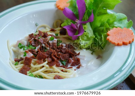 A closeup picture of a spaghetti with bacon, ham and cream sauce. 
