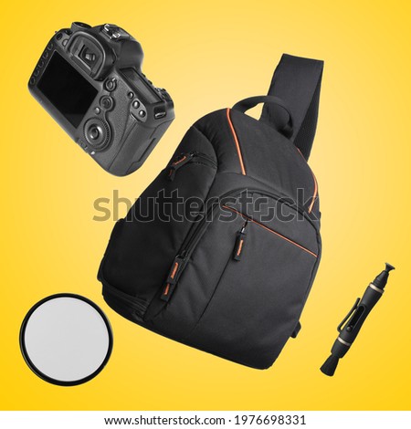 Different professional photography equipment falling on yellow background Royalty-Free Stock Photo #1976698331