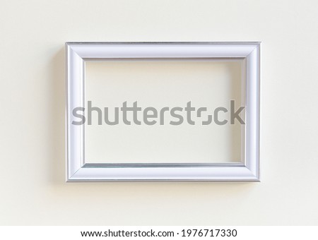 Blank white picture frame on a plain beige background. Empty poster mockup for art display.  No people.