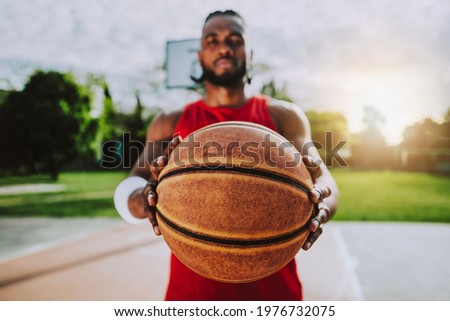 Portrait of a basketball player holding ball with hands - Athlete concentrating on game - Selective focus on the ball