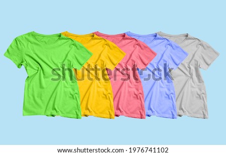 Collection of bright t-shirts on color background