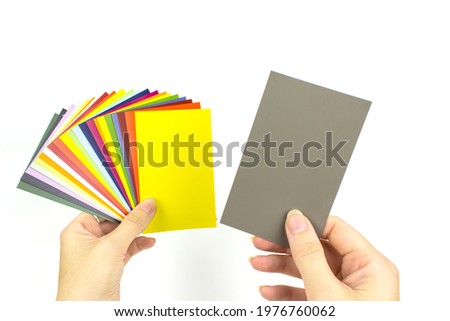 Hands holds acolor palette of paints on a white background. Color card paint samples.