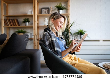 Happy young woman using tablet pc in loft apartment