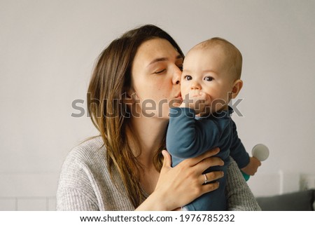 A young mother is play with little baby boy. Mother of a nursing baby. Happy motherhood. The family is at home. Portrait of a happy mother and child.