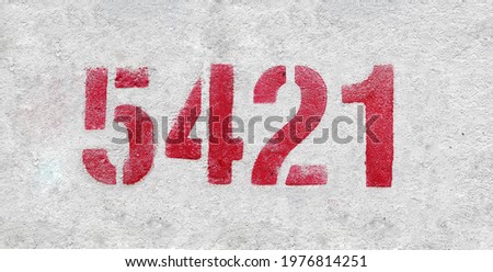 Red Number 5421 on the white wall. Spray paint.