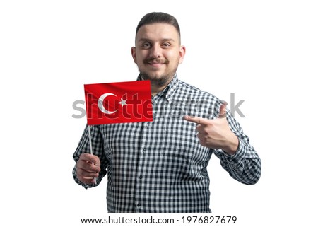 White guy holding a flag of Turkey and points the finger of the other hand at the flag isolated on a white background.