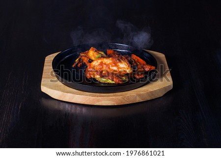 fajitos, meat in a frying pan with fire on a wooden tray, beautiful serving, dark background.