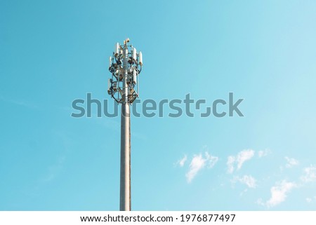 Cellular macro Base Transceiver Station. Telecommunication tower. Wireless Communication Antenna Transmitter. Development of communication systems in urban area blue sky Royalty-Free Stock Photo #1976877497