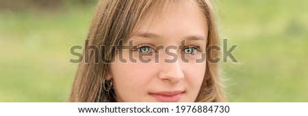 Large scale portrait of unique young brunette woman looking in camera outdoor