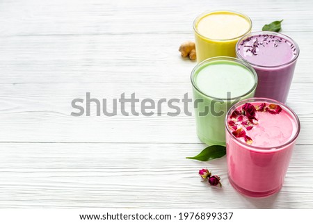 Green, yellow and pink latte. Hot colorful coffee or tea with milk