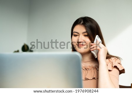 successful business woman in office with laptop and phone	