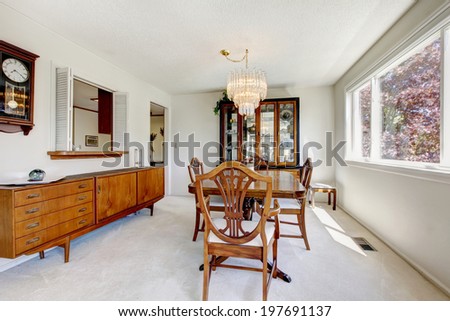 Bright dining room with antique wooden furniture and light tone carpet floor