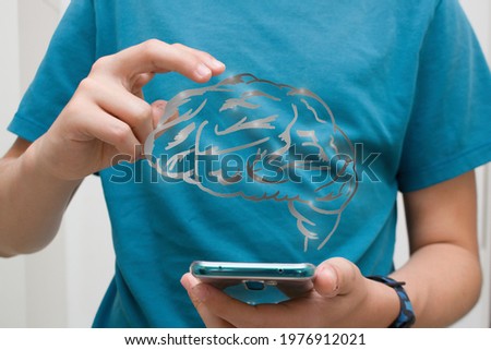 A boy or man holds a phone in his hand with a cartoon brain over it. Technologies are smart.