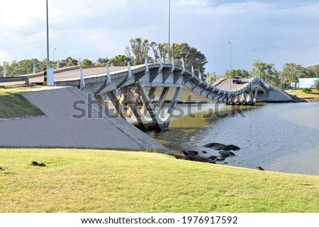 Photography of a modern bridge over a river under a cloudy sky