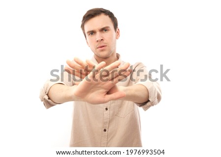 Portrait of brunette man in casual showing stop gesture, no please, you are refused isolated on white studio background