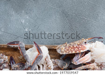 Frozen raw blue swimming crab meat set, on wooden tray, on gray background, top view flat lay , with copyspace  and space for text