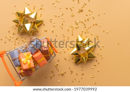 In the photo there are candies in a vase. Also, golden confetti is scattered on a light beige background. Decor. Beautiful festive still life. Bright lighting. There are no people in the photo.