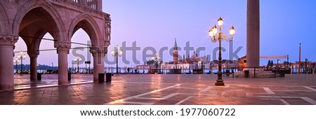 Banner, San Marco square at night, early morning. Venice or Venezia city, Italy, Europe. Panoramic composition, illuminated architecture, image toned purple. Gondolas moored by the pier.