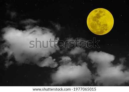 Yellow full moon and white clouds on the sky.