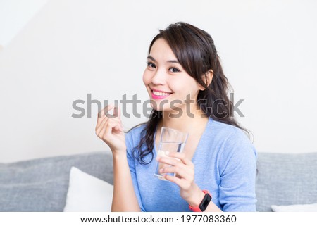asian young woman holding a glass of water with vitamin has healthy life and she smile at you Royalty-Free Stock Photo #1977083360