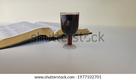 An open Holy Bible, glass of wine, white background. Religious symbols. Space for text..