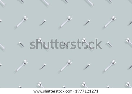 Adjustable metal wrench seamless pattern. Background from a metal wrench and a bolt. 