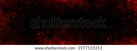 Fire embers particles over black background. Fire sparks background. Abstract dark glitter fire particles lights. bonfire in motion blur. Royalty-Free Stock Photo #1977133313