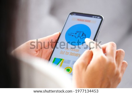 Close up of woman hands checking parcel delivers order on mobile app while sitting on the sofa at home during the quarantine, Delivery application on smartphone device screen
