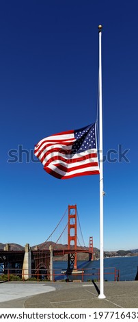 An American flag flowing in the wind against a background of Golden Gate Bridge, San  Francisco.