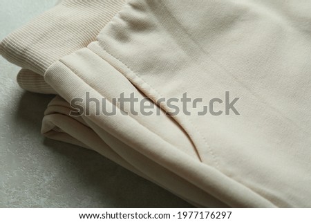 Folded sweatpants on white textured background, close up Royalty-Free Stock Photo #1977176297